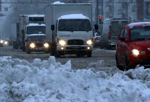 Vehicles drive during a heavy snowfall in Moscow.