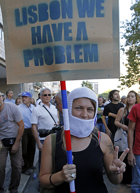 A woman holds a banner saying during a march against austerity in Lisbon.