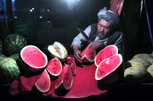 An Afghan man sells watermelons on his cart along a street as he waits for customers at the old part of Kabul.