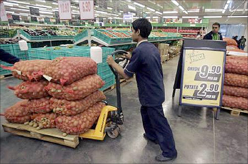 A worker pushes a cart of potatoes at a Metro cash-and-carry outlet in Kolkata.