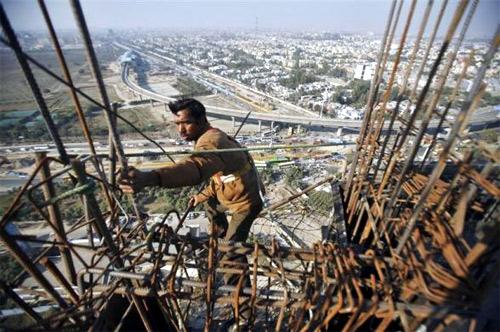 A labourer works at the construction of a residential complex at Noida in Uttar Pradesh.