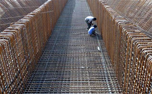 Labourers work at the construction site of a flyover on the outskirts of Ahmedabad.