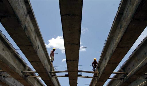 Workers stand at the construction site of a flyover bridge in Chennai.
