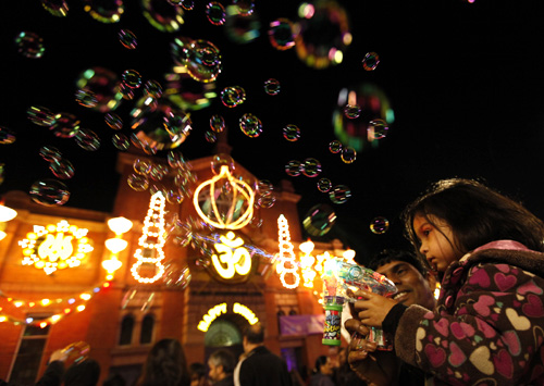 A girls shoots bubbles from a gun during the start of Diwali celebrations in Leicester, central England.