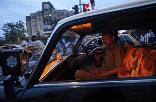 Vinay, 30, a taxi driver, looks out from his Premier Padmini taxi as he waits at a signal during rush hour in Mumbai.