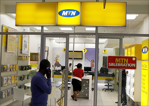 A man speaks on a mobile phone as he walks past a MTN shop at a shopping mall south of Johannesburg.
