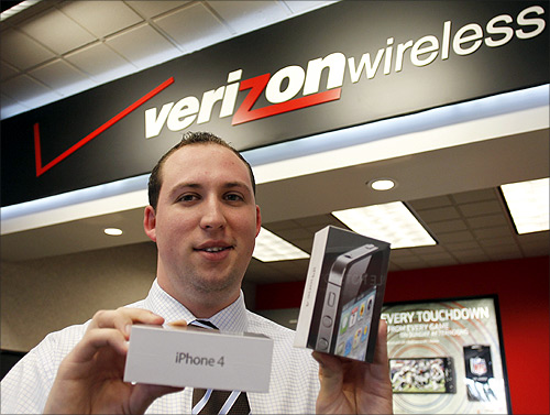 Chris Gates, assistant manager at a Verizon Wireless store, holds the new Verizon iPhones at his store in Boca Raton, Florida.