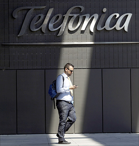 A man checks his phone outside Telefonica headquarters in Madrid.