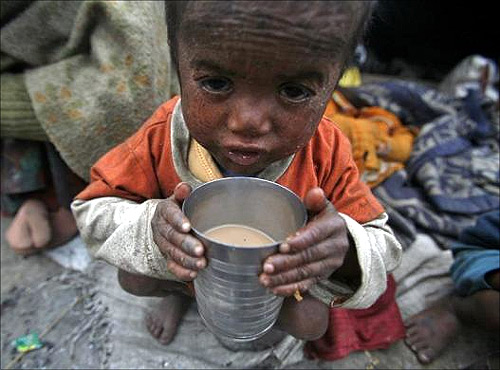Three-year-old Babu, a child of a migrant labourer, holds a glass filled with tea outside a makeshift tent along a road on a cold morning in Noida in Uttar Pradesh.