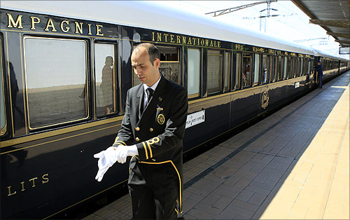 A car attendant puts on his gloves in front of the Orient Express at the main railway station in Bucharest September 3, 2012.