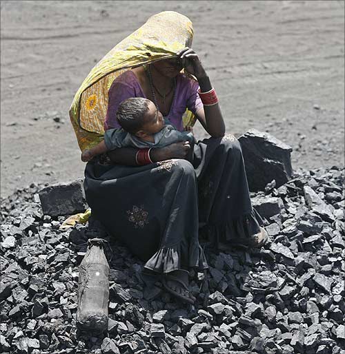 A woman labourer holds her child at a coal yard on the outskirts of  Ahmedabad.