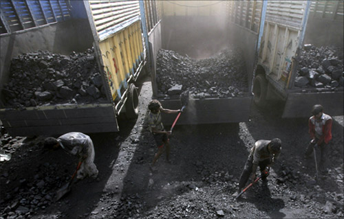 Labourers load coal onto trucks at a coal yard on the outskirts of Jammu.