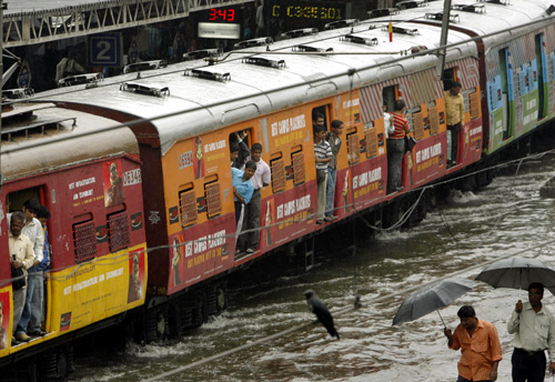 A train moves through a flooded track after heavy rains in India's financial capital Mumbai.