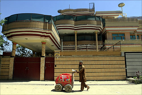 An Afghan man sells ice cream as he walks in front of a Swiss-based Medair office in Kabul.