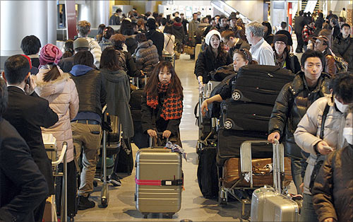 Passengers queue to check into a flight at Narita airport, east of Tokyo.