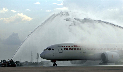 Air India's Dreamliner Boeing 787 is given a traditional water cannon salute by the fire tenders upon its arrival at the airport in New Delhi.