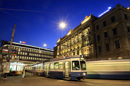 Trams drive past the offices of Swiss banks UBS (L) and Credit Suisse at Paradeplatz square in Zurich.
