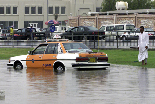 A taxi driver looks in dismay at his car after it got stuck on a flooded road in Doha.