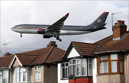 A Royal Jordanian airways jet arrives over the top of houses to land at Heathrow Airport in west London.