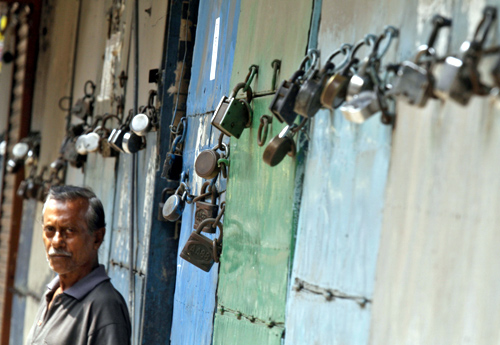 A man stands in front of closed shops during a nationwide strike in Kolkata.