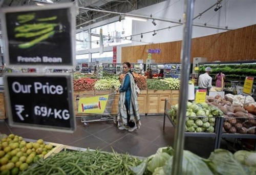 A woman pushes a shopping trolley in the fresh food section at a retail supermarket in Mumbai.