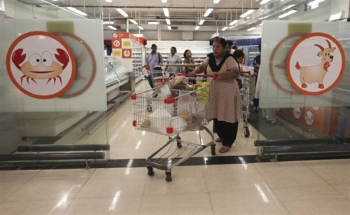 A woman pushes a trolley as she exits the meats section of a Reliance Fresh supermarket in Mumbai.