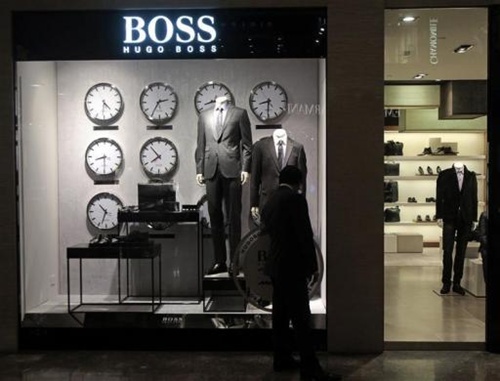 A man looks at a shop window outside the Hugo Boss showroom inside a shopping mall in Mumbai.