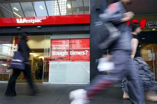 Pedestrians walk past an electronic display board in front of a Westpac bank in Queen Street, downtown Auckland.