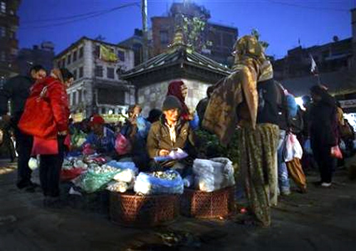 A street vendor sells mushrooms to a customer at Ashon, one of the busiest market places, in central Kathmandu.