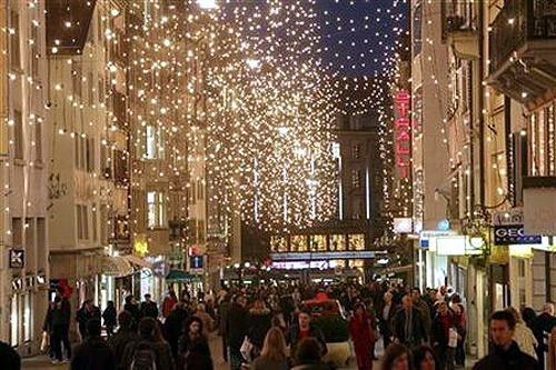 Shoppers walk under Christmas illuminations on Rennweg street in Zurich.