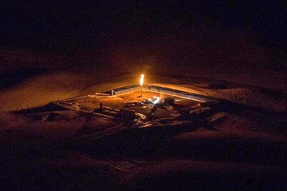 An aerial image shows a natural gas flare after sunset outside of Williston, North Dakota.