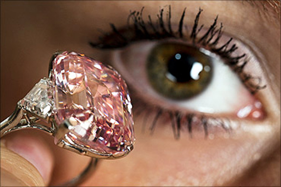 An employee poses with a 24.78 carat Fancy Intense Pink diamond at Sotheby's in Geneva.
