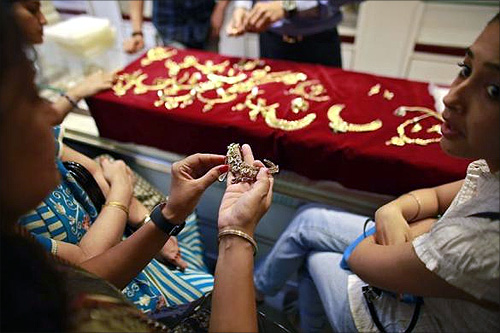 A customer holds a gold necklace inside a jewellery showroom in Mumbai.