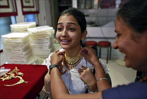 A girl tries a gold necklace inside a jewellery showroom in Mumbai.