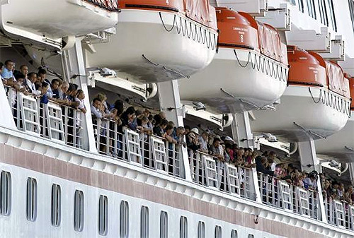 Passengers clap as the Carnival Cruise Lines cruise ship C/V Splendour docks after being towed into San Diego harbour.