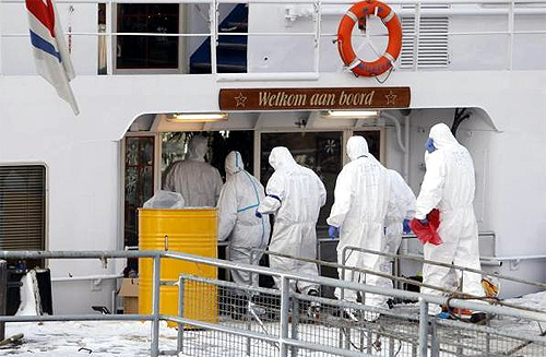 Paramedics dressed in protective attire enter the ship, the Bellriva, in Wiesbaden.