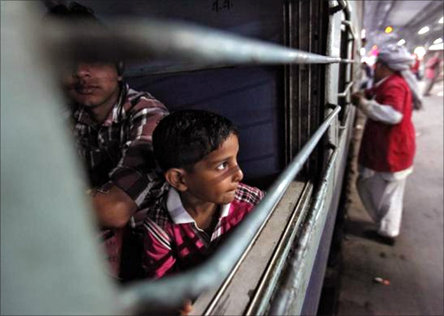 A boy looks out of a compartment of the Kalka Mail passenger train at a railway station in the old quarters of Delhi.
