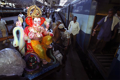 People load an idol of the Hindu elephant God Lord Ganesha onto a train at a railway station in Mumbai.