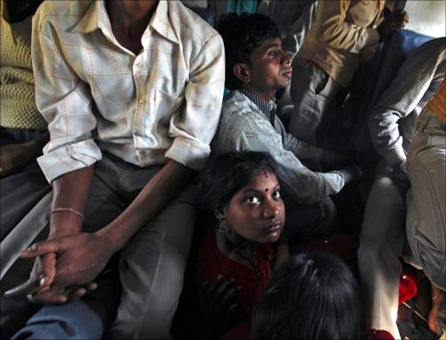 Passengers sit on the floor while travelling inside an overcrowded general class compartment of the Kalka Mail train.