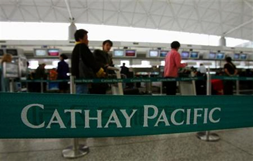 Passengers wait in line at a Cathay Pacific Airways check-in counter at the Hong Kong international airport.