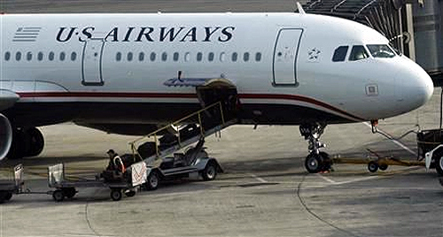 A worker is seen loading luggage on a plane from US Airways at Newark Liberty International Airport in Newark, New Jersey.