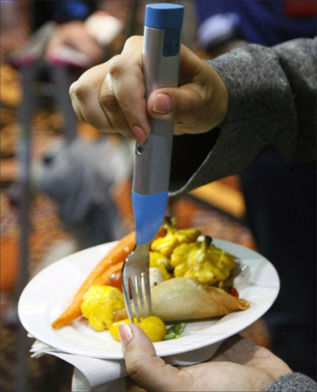 A reporter tries out the HAPIfork at the opening press event of the Consumer Electronics Show (CES) in Las Vegas.