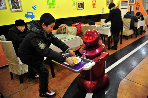 A robot that specialises in delivering food serves a customer with French fries at a Robot Restaurant in Harbin, Heilongjiang province.