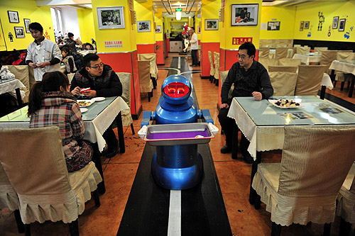 A robot that specialises in delivering food holds an empty plate after serving meals to customers at a Robot Restaurant in Harbin, Heilongjiang province.