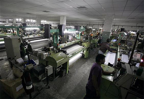 Employees work inside a linen cloth weaving unit at Palsana village, on the outskirts of Surat, in Gujarat