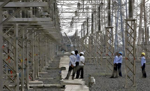Engineers inspect electric transmission lines at Adani Power Company thermal power plant at Mundra in Gujarat.