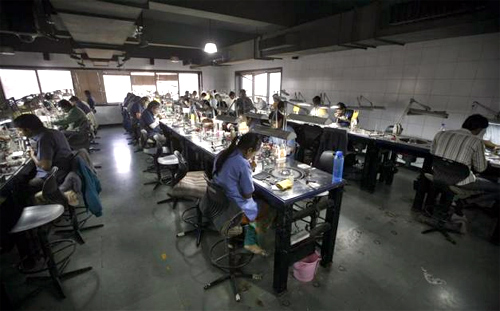 Employees work inside the polishing department of a diamond processing unit at Surat, in Gujarat.