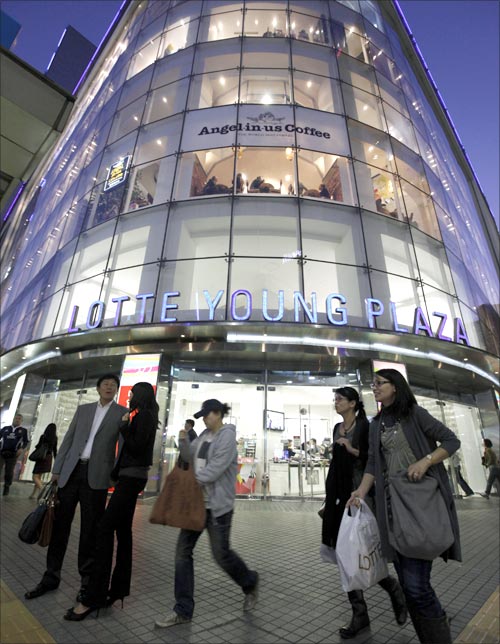 People walk past a Lotte Shopping mall in Seoul.