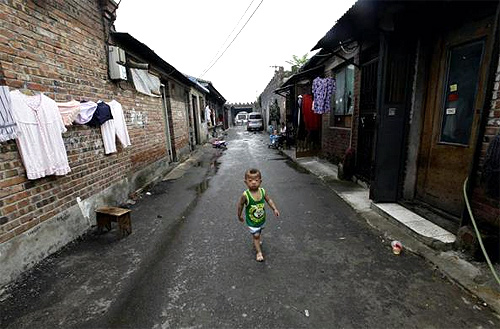 A boy walks past houses in a residential area for migrant workers in Beijing.