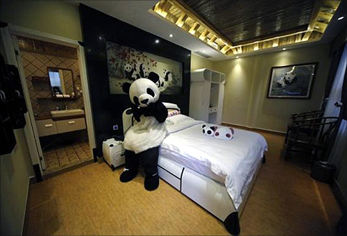 An employee dressed in a panda costume poses for a photo during the soft opening of a panda-themed hotel at the foot of Emei Mountain, Southwest China's Sichuan province.